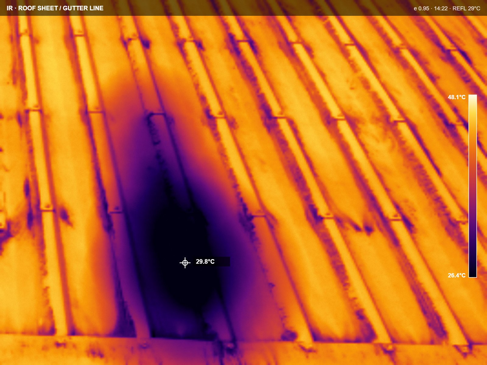 Thermal frame of the same roof sheeting, ironbow palette, with a cooler patch across two sheets and a temperature scale